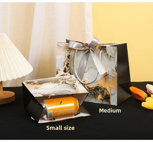 Detail view of marble pattern gift bags in medium and small sizes with satin bows