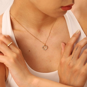 Close-up of 18K gold plated heart pendant necklace with zircons on female model