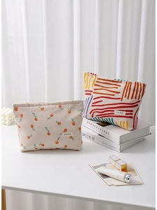 Floral and striped corduroy cosmetic bags with zipper closure on a desk