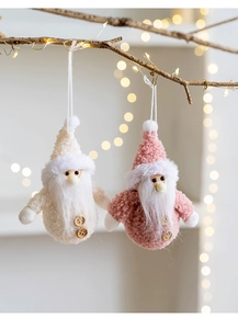 Close-up of handmade fabric Christmas dolls with wood buttons hanging on festive branches