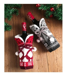 Christmas knit wine bottle covers featuring reindeer and snowflake patterns on wood