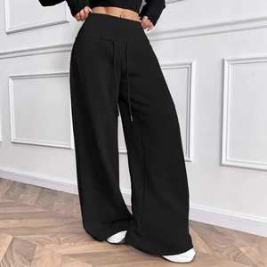 Detail of black wide-leg joggers featuring a drawstring waist on a modern fashion model