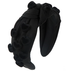 Close-up of black wide knot headband with textured rib knit fabric and velvet heart charms