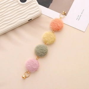 Detailed view of colorful fur ball metal chain accessories in orange, yellow, and green