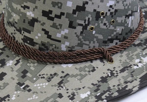 Gros plan d'un chapeau de cow-boy camouflage avec corde tressée et œillets métalliques