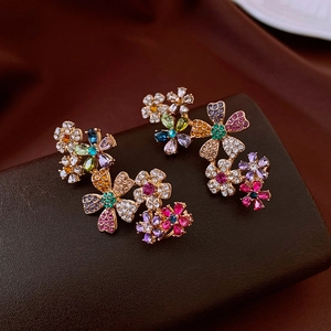 Detail of 18k gold plated floral earrings with colorful crystal inlay on leather box