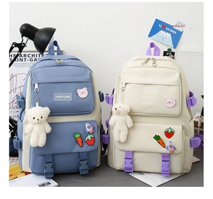 Detail of Korean style canvas backpacks in blue and cream with cute bear charms