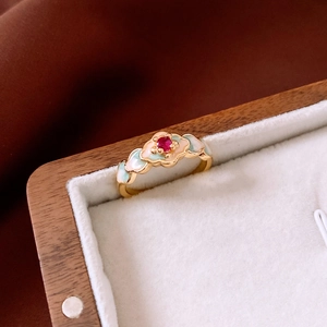 Detail of 18K gold-plated vintage ring with red gem and floral enamel in jewelry box