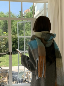 Close-up of thick multi-color plaid scarf with soft brushed wool texture and fringe edge