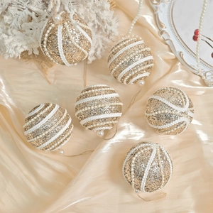 Exquisite gold and white Christmas balls with glitter and pearls on silk background