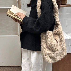 Detailed view of beige faux shearling tote bag with brown straps and plaid lining detail