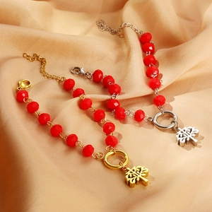 Detailed view of red crystal bead bracelets with tree of life charms on gold silk