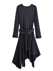 Detail of black asymmetrical dress featuring metal belt buckle and decorative studs