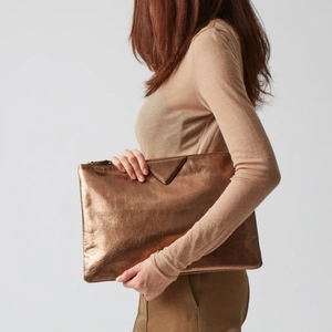 Detail of glittery bronze PU leather envelope clutch bag with triangular flap and zipper