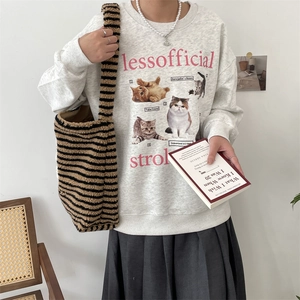 Detail of grey sweatshirt with realistic cat print and striped knit tote bag