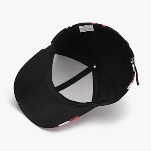 Internal view of black cotton baseball cap showing red and white brim details and metal buckle