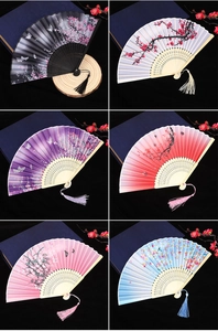 Detailed view of six vintage Chinese folding fans with floral patterns and silk tassels