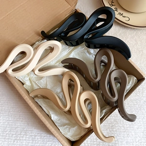 Acrylic wavy claw clips in four matte neutral earth tones for thick hair styling