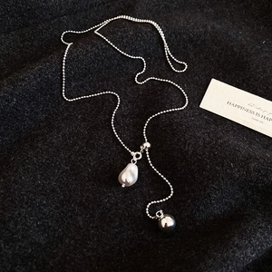 Detail of silver bead chain necklace featuring a baroque pearl and Y-shaped pendant design