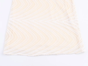 Close-up of wavy sequin patterns and bead embroidery on beige mesh evening dress fabric