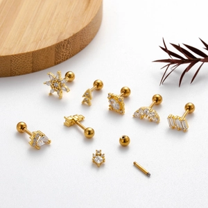Golden stud earring set with zircon stars and geometric shapes on a minimalist background