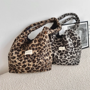 Detail of faux shearling leopard tote bag featuring textured fabric and brand patch