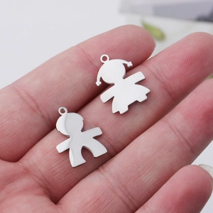 Macro shot of silver boy and girl character pendants on palm showing size and metal detail