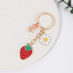 Detail view of a gold zinc alloy keychain with strawberry, daisy and heart charms