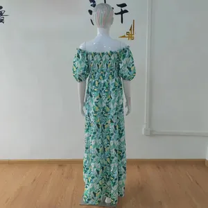 Vista trasera de un vestido largo bohemio con estampado floral verde y falda de volantes