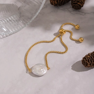 Gold box chain bracelet featuring a large baroque pearl with adjustable slide clasp