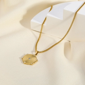 Detail of 18K gold hexagonal sunburst necklace featuring white zircon stones on a pedestal