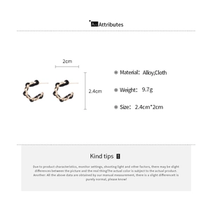 Vue détaillée des boucles d'oreilles en C avec alliage doré et tissu noir tressé