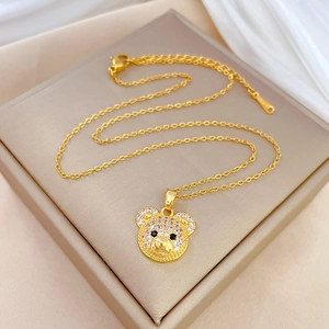 Lussuosa collana con orsetto d'oro impreziosita da cristalli su sfondo di seta