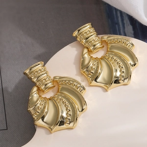 Detailed view of gold-plated geometric shell earrings with beaded texture and fan design