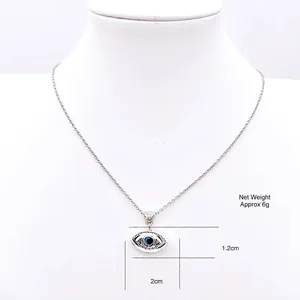 Evil eye pendant necklace with blue eye stone on a silver chain worn on a white neck bust