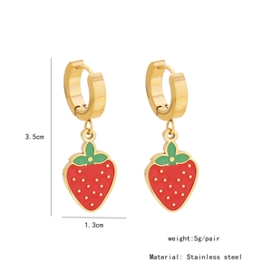 Detail of gold stainless steel earrings featuring red and green enamel strawberry pendants