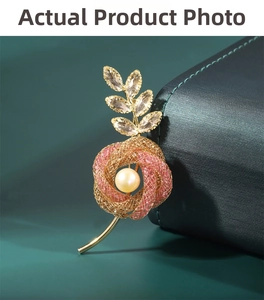 Detailed macro of a gold flower brooch with pink mesh petals and a central freshwater pearl