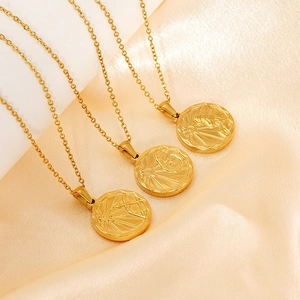 Gold round medallion necklace with sun relief on champagne silk fabric background