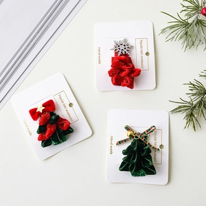 Three Christmas reindeer antler headbands with velvet stars and bows on display card