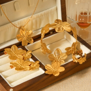Detailed macro view of matte gold flower jewelry set in a luxury wooden box