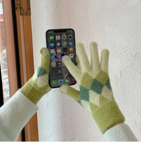 Detail of green and white diamond knit gloves featuring touchscreen fingertips for women