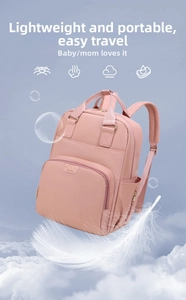 Pink lightweight multifunctional diaper backpack floating among clouds and feathers