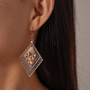 Detail of bohemian rhombus earrings with wood beads and vintage bronze tassels
