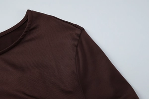 Détail du col rond et des coutures d'épaule d'une robe marron foncé à manches longues