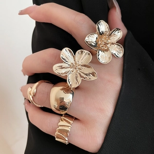 Close-up of gold flower pea open ring set with crystals on a hand in lifestyle view