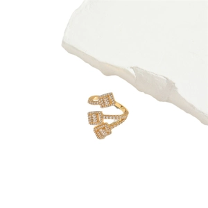 Gold-plated open crossover ring with sparkling zircon inlays on a textured stone