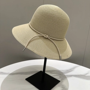 Chapeau de soleil en paille beige à large bord avec un cordon aux embouts métalliques