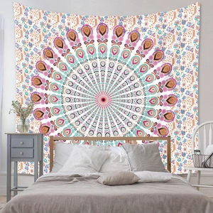 Détail d'une tapisserie mandala bohème avec motifs de paon suspendue dans une chambre