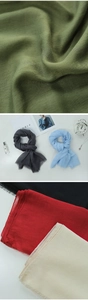 Detail view of multicolored linen scarves with fringes including green and grey tones