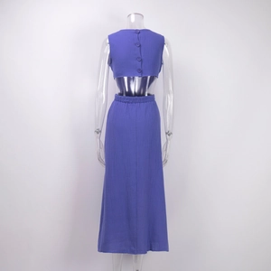 Detail of purple two-piece dress showing back buttons and pleated fabric texture